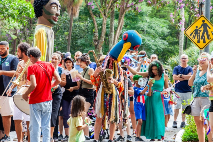 Baile de carnaval no Boulevard do Parque da Ciência, com pessoas dançando de roupas coloridas e fantasias