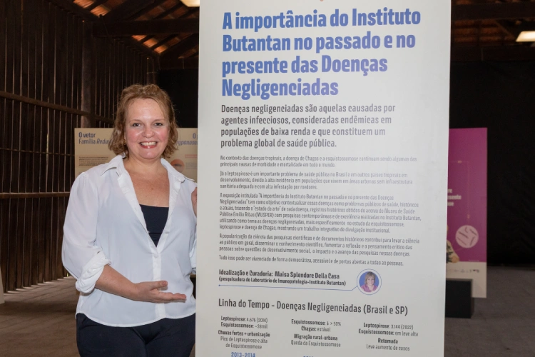 Idealizadora da exposição em frente ao totem de abertura
