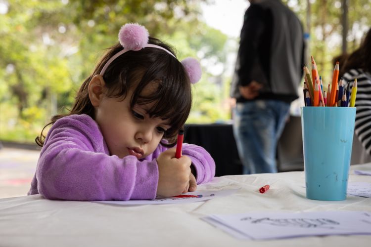 Criança desenhando em ambiente externo ao Museu da Vacina do Butantan